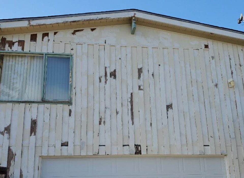 Peeling exterior paint on wood siding before preparation in San Diego