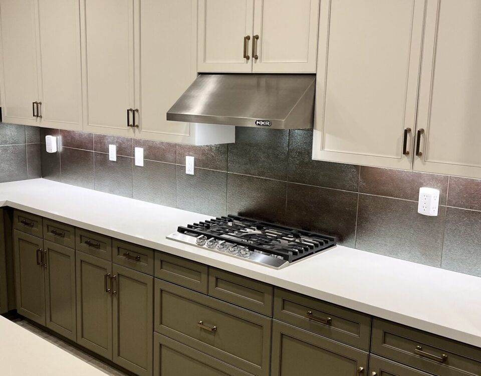 Finished San Diego kitchen with warm white upper cabinets above deep green lowers, sprayed to a smooth factory-like finish